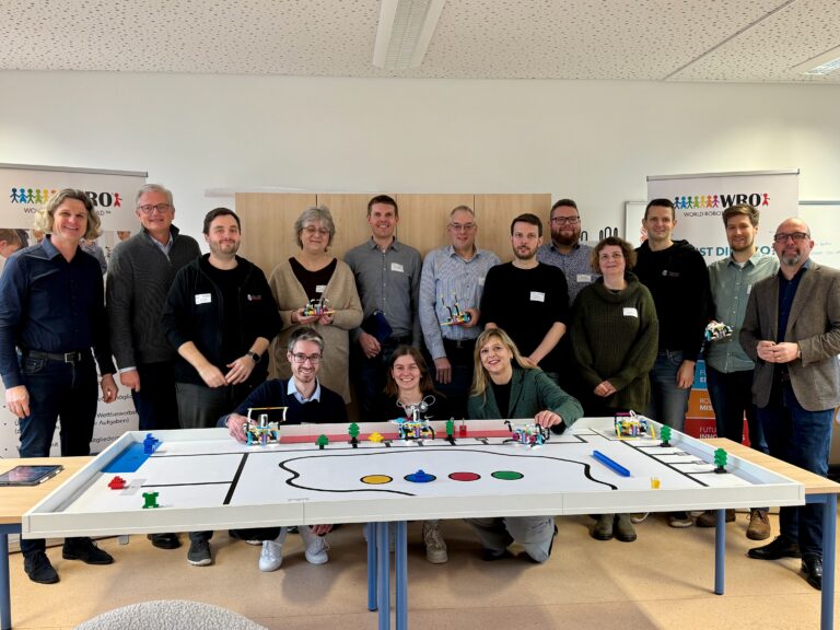 Personen hinter einem Spielfeld der WRO